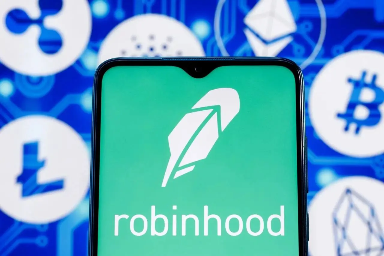 Экран телефона с логотипом Robinhood на фоне иконок криптовалют